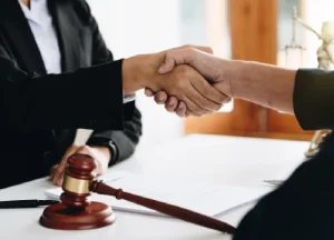 Lawyer shaking hands with a client during a legal consultation.