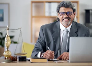 Experienced lawyer smiling while reviewing documents in a professional office setting.
