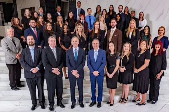 Attorneys and staff of Danziger & De Llano, LLP gathered on a staircase