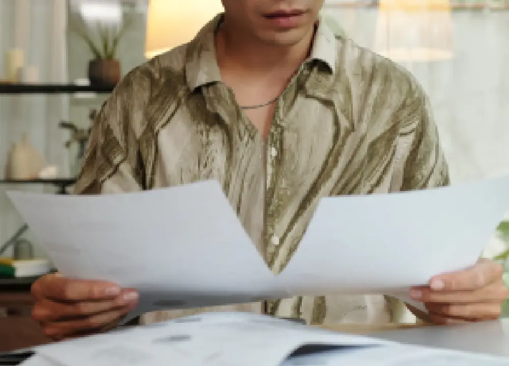 Hands comparing legal paperwork on a desk.