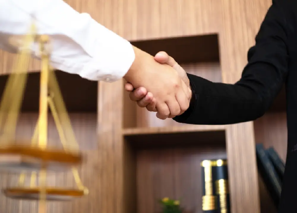 Close-up of a professional handshake between a lawyer and a client symbolizing trust and partnership.
