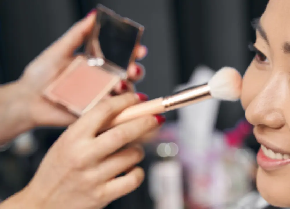 Person applying makeup as part of a daily personal care routine.