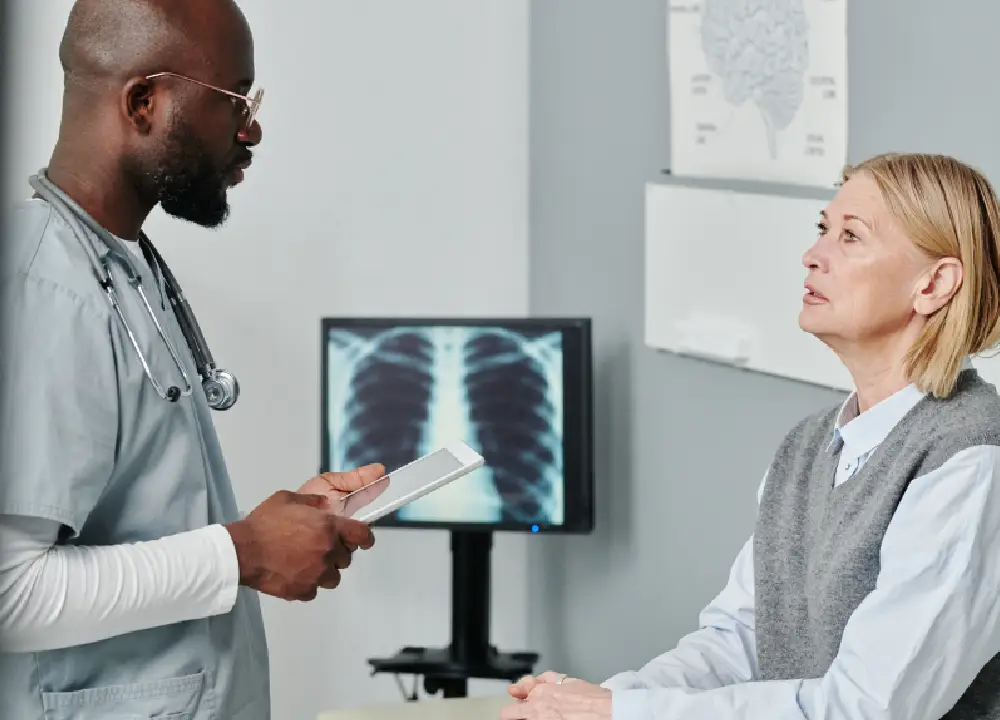A doctor and patient reviewing a chest X-ray to identify potential respiratory issues linked to talc exposure.