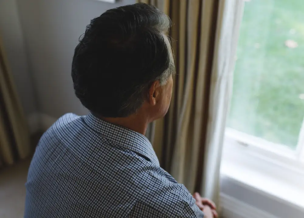 Person looking out a window during a quiet moment of reflection.
